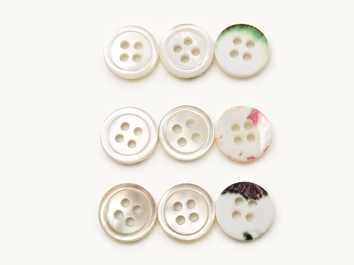 nine natural shell buttons with pearl grain and colored natural edge patterns